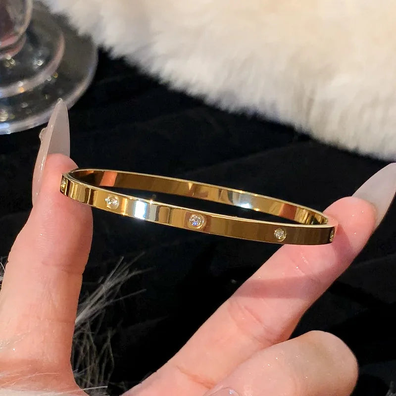 Bracelet en acier inoxydable et titane, plaqué or et zircons incrustés